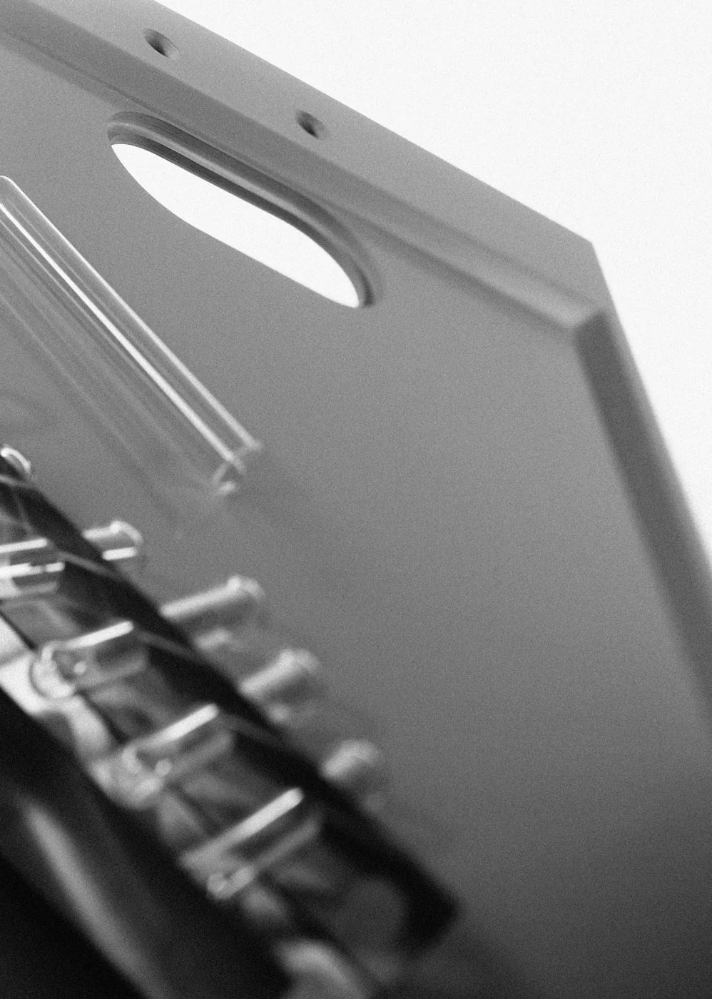 Detail of an epoxy resin fume cupboard base with service pipework beneath, in black and white