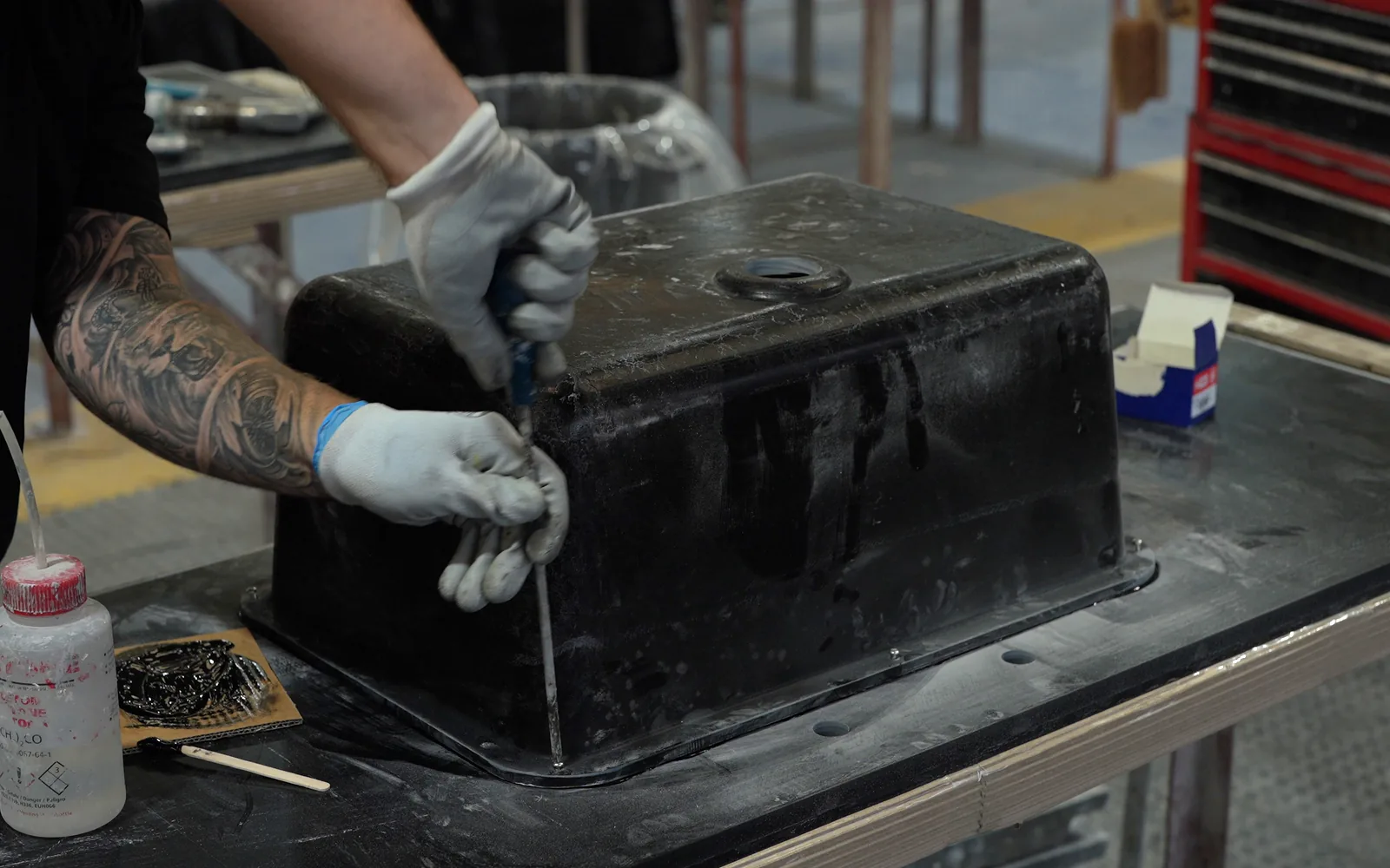 Finishing the joint between a black sink and a worksurface by hand